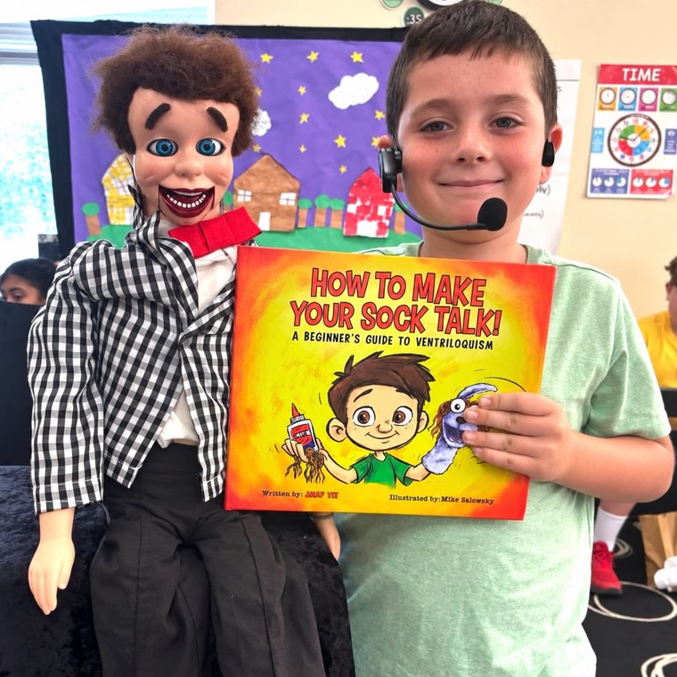 Tommy holding his figure Danny and a copy of How to Make Your Sock Talk